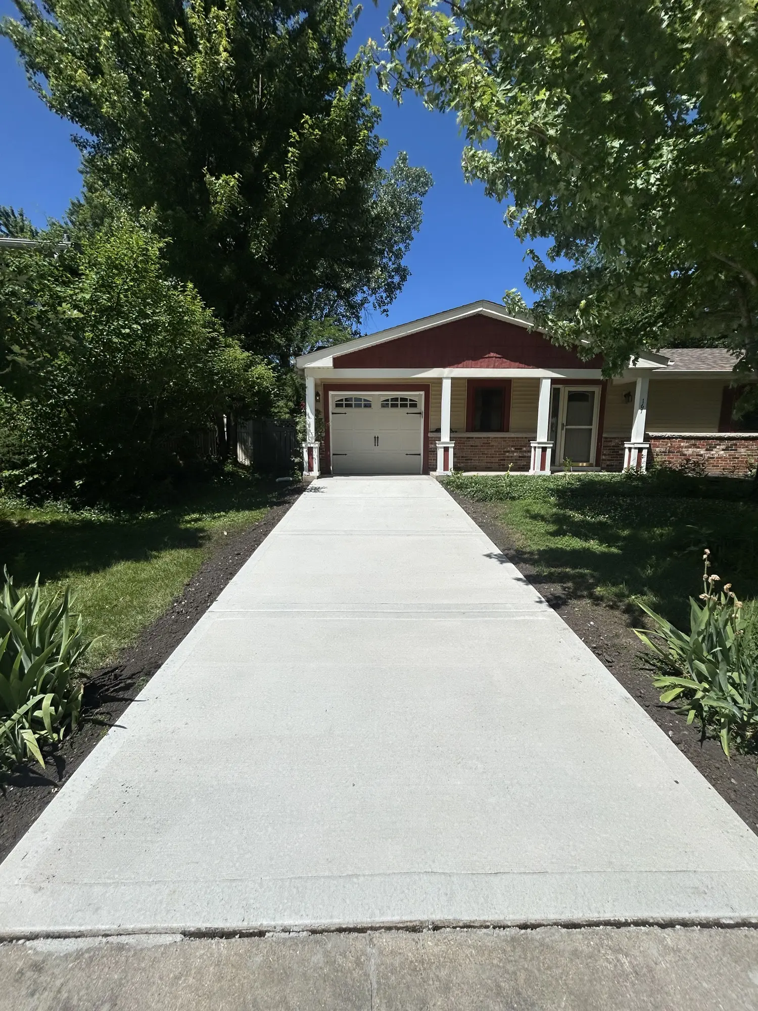 New broom-finished concrete driveway leading to a single-car garage near Chicago