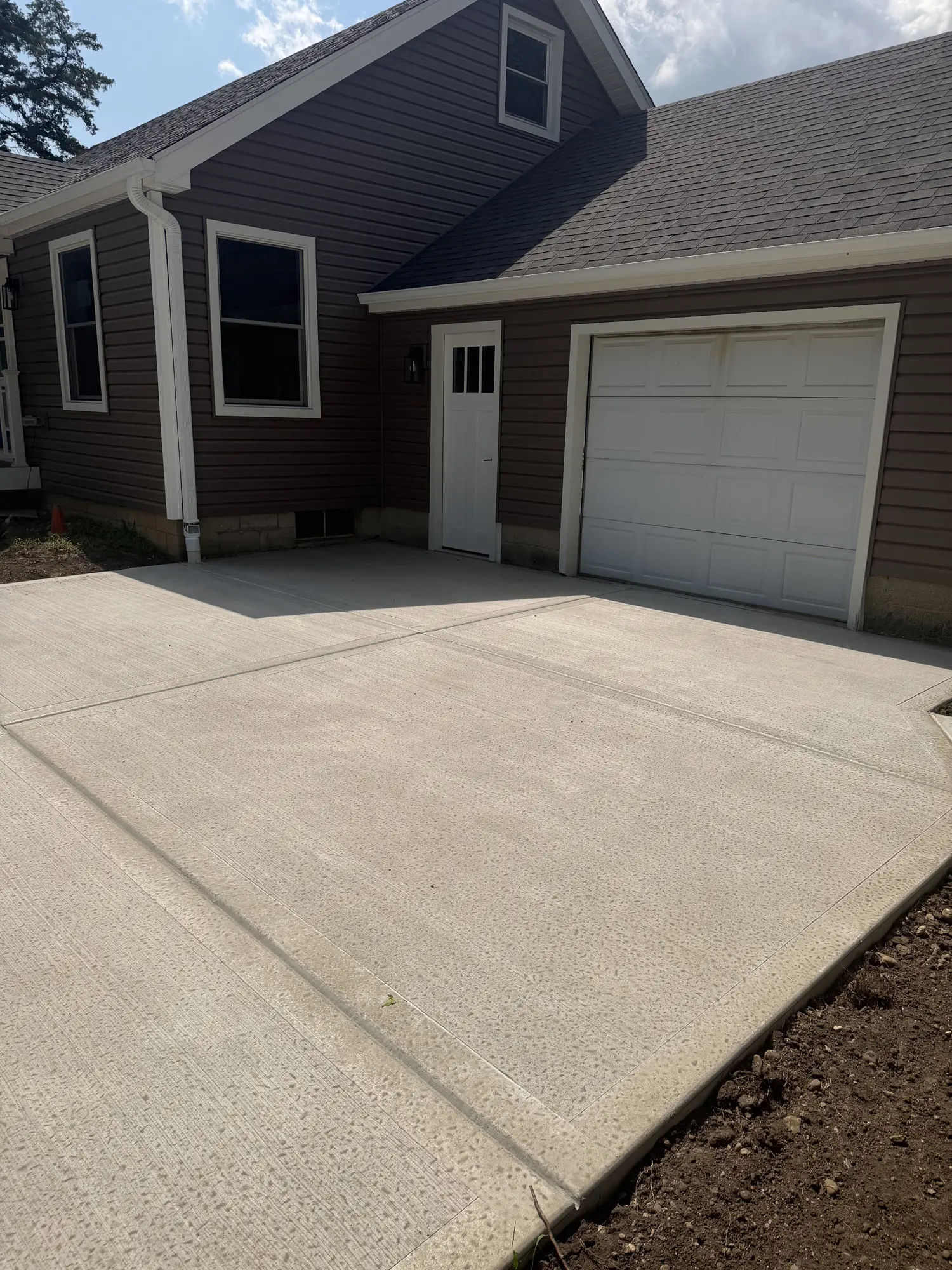 Concrete driveway pad in front of an attached garage by FPI Construction
